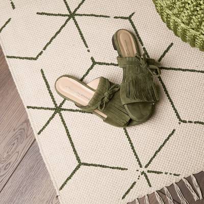 Detailaufnahme Designteppich in creme und grün mit Fransen von Heineking24